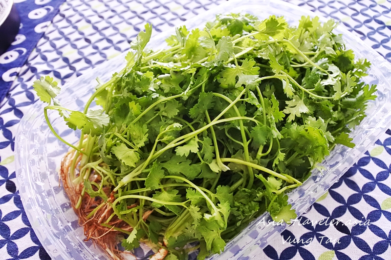 プラスチックトレーに山盛りのパクチー（rau mui）根付き