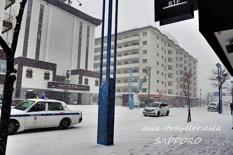 大雪が降る札幌市街をタクシーが走る冬景色