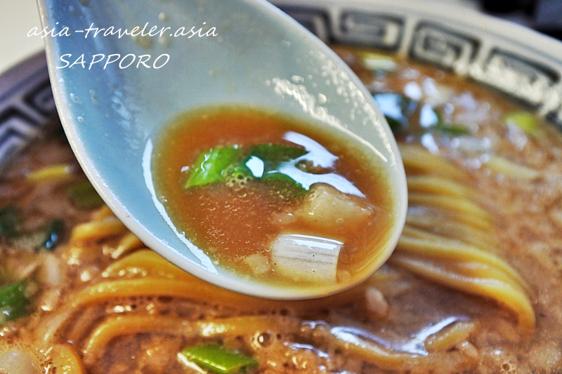 札幌・風棶堂の旭煮干し中華そばスープをすくう蓮華