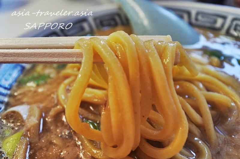 札幌・風棶堂の旭川中華そば太麺を箸で持ち上げたアップ