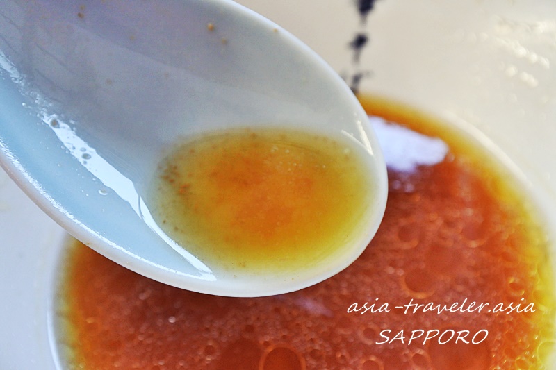 風棶堂・新麦中華そばの鶏醤油スープをレンゲで掬う