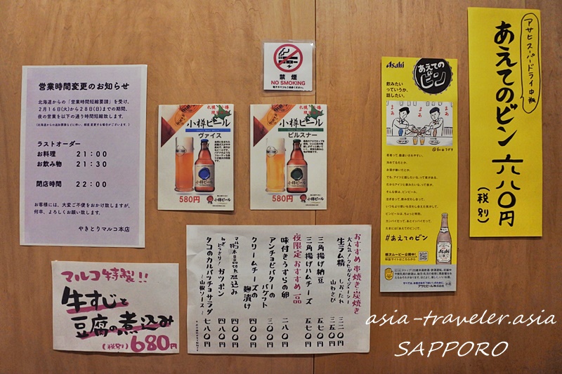 やきとりマルコ本店の壁に貼られたメニューと小樽ビールのポップ