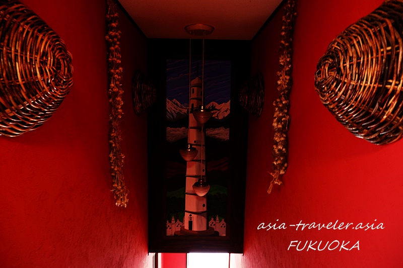 灯台の絵が描かれたナングロガル福岡の赤い壁の店内通路
