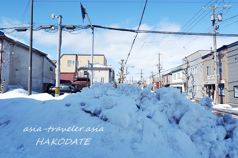 函館・大町の路地に積み上げられた雪山と冬の街並み