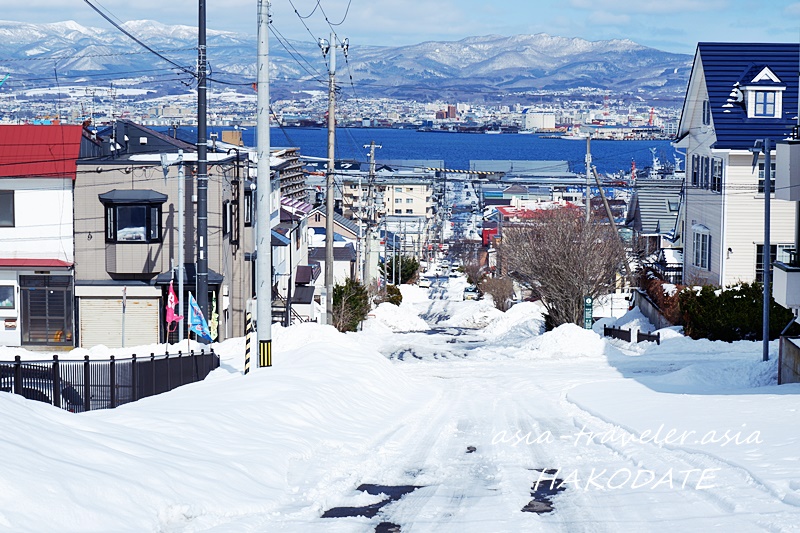 函館の雪に覆われた急坂と函館港を望む冬景色