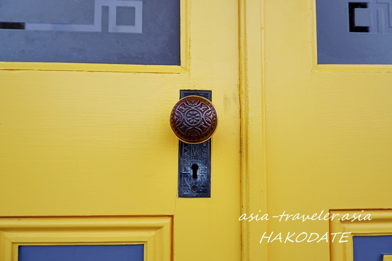 旧函館区公会堂のイエローのドアと装飾ノブのクローズアップ