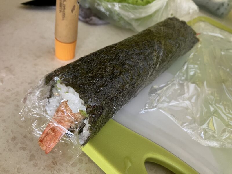エビフライ入り海苔巻きをラップで包んだ手作り昼ごはん