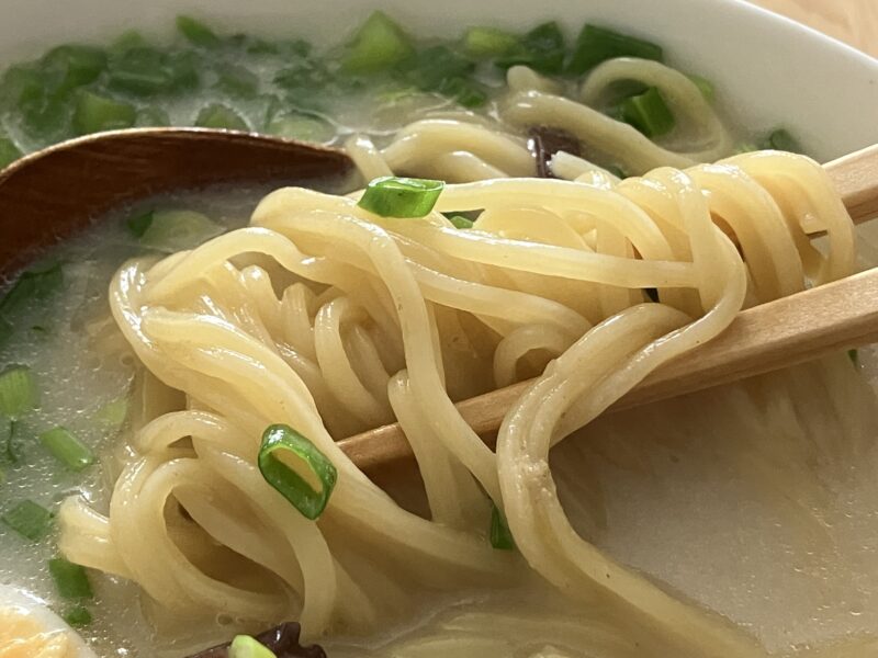箸で持ち上げたベトナムラ王の豚骨ラーメン麺アップ