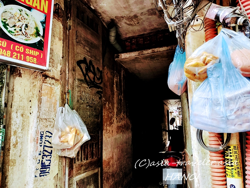 ハノイ旧市街の路地裏に並ぶ食料品入りビニール袋と古びた建物