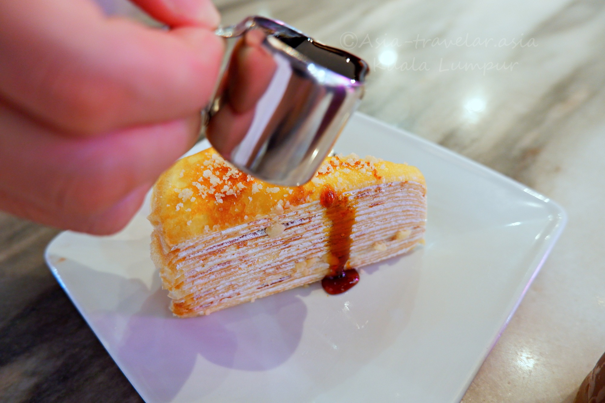 クアラルンプール空港カフェのミルクレープにグラ・マラッカをかける瞬間