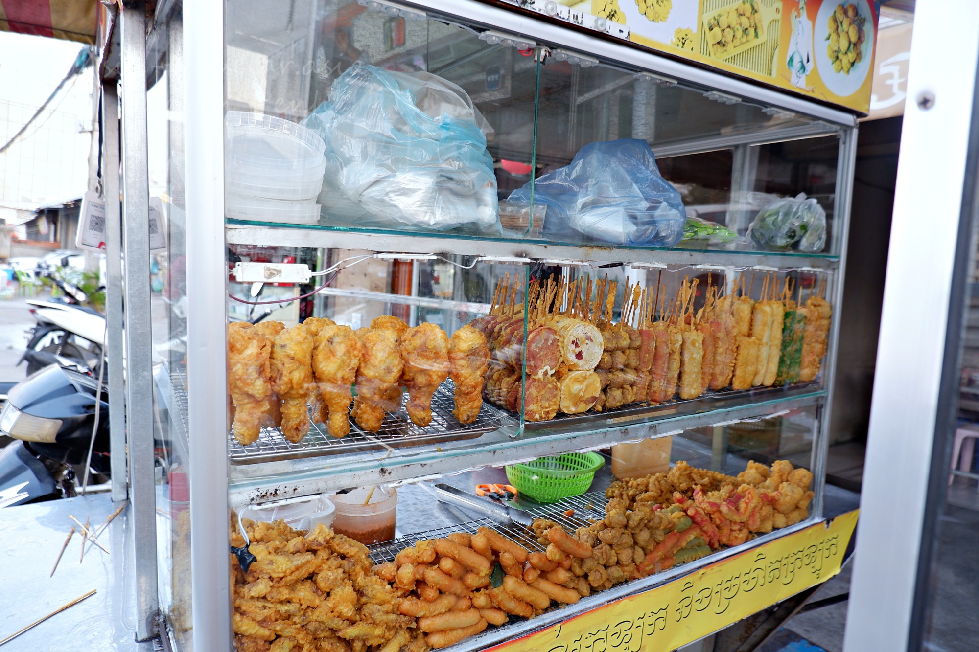 プノンペンの屋台に並ぶ揚げ物・串料理のガラスケース