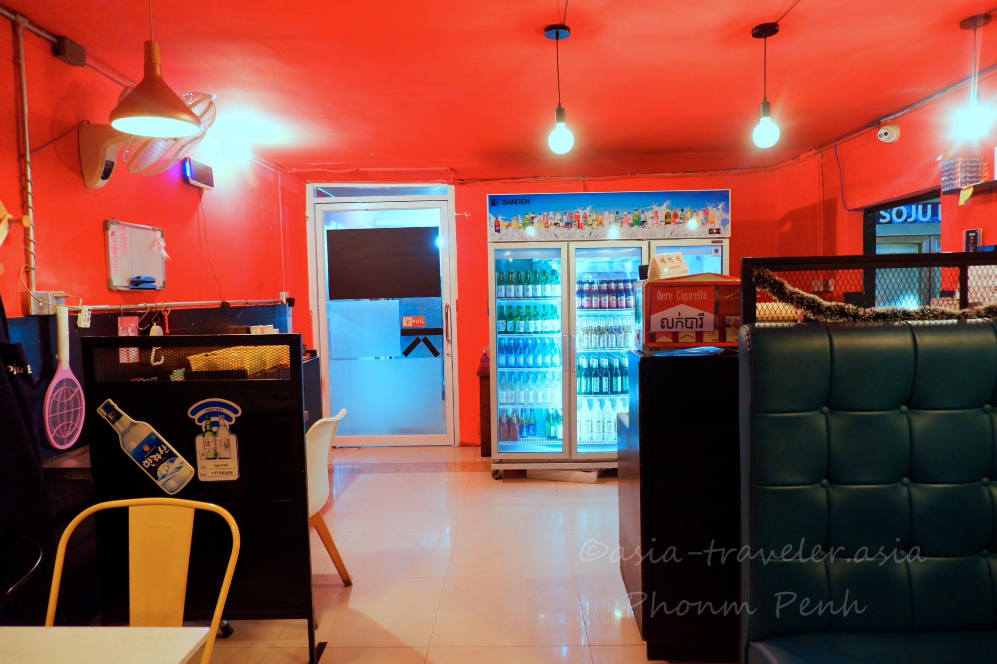 プノンペンSoju Barの赤い壁とドリンク冷蔵庫が並ぶ店内