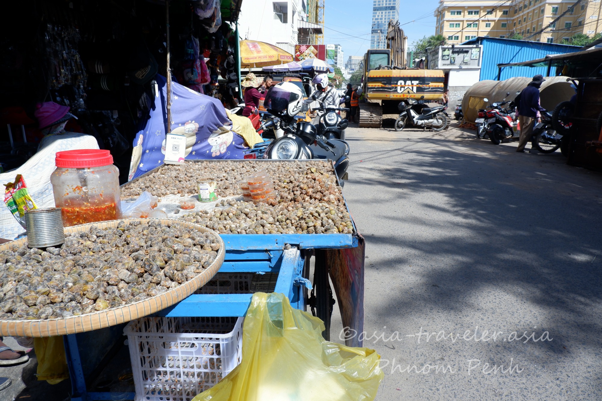 プノンペンの路上で塩辛子まぶした貝を販売する屋台