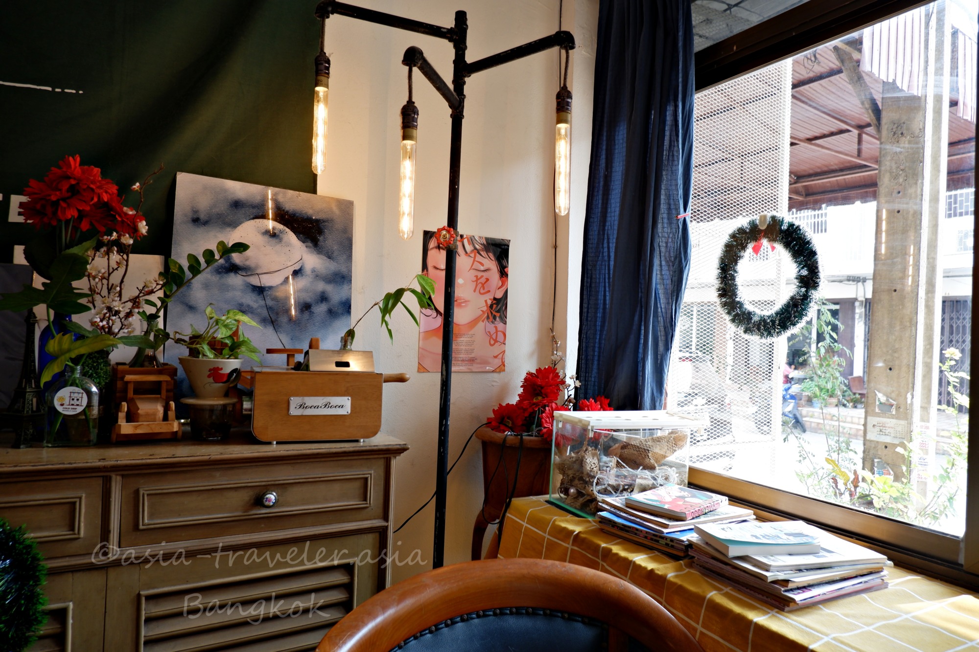 バンコクのカフェ店内、アンティーク調の棚とエジソンランプが並ぶ温かみのある空間