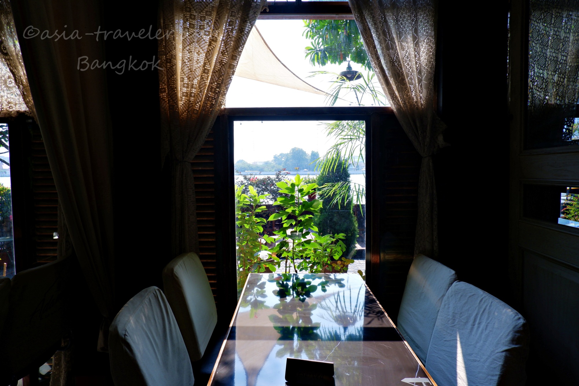 バンコクのカフェ窓越しにチャオプラヤ川を望む落ち着いた店内席