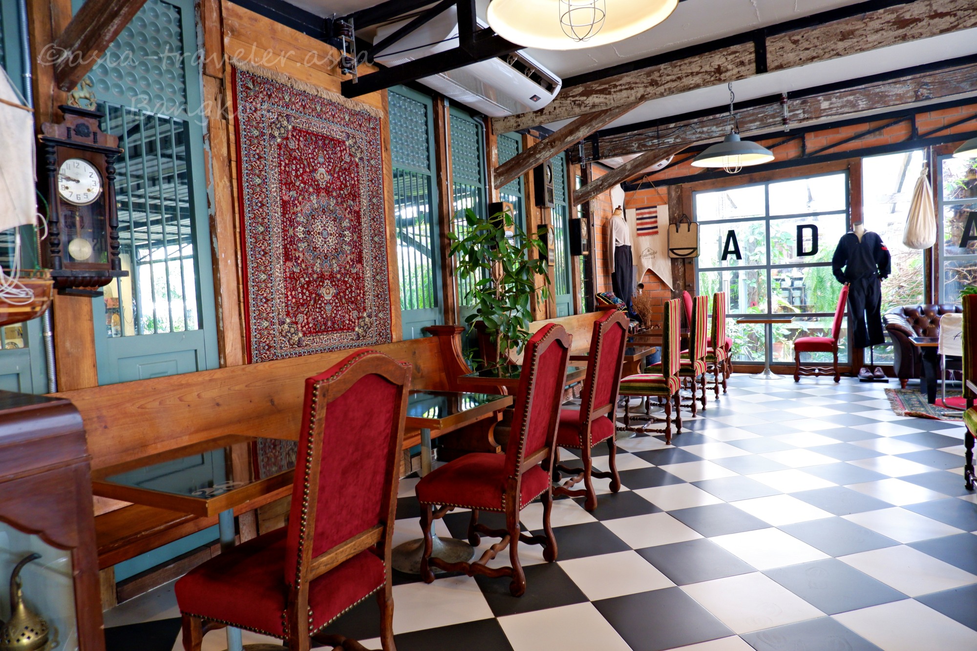 モノクロタイルとアンティーク家具が並ぶAdamus Cafeの店内