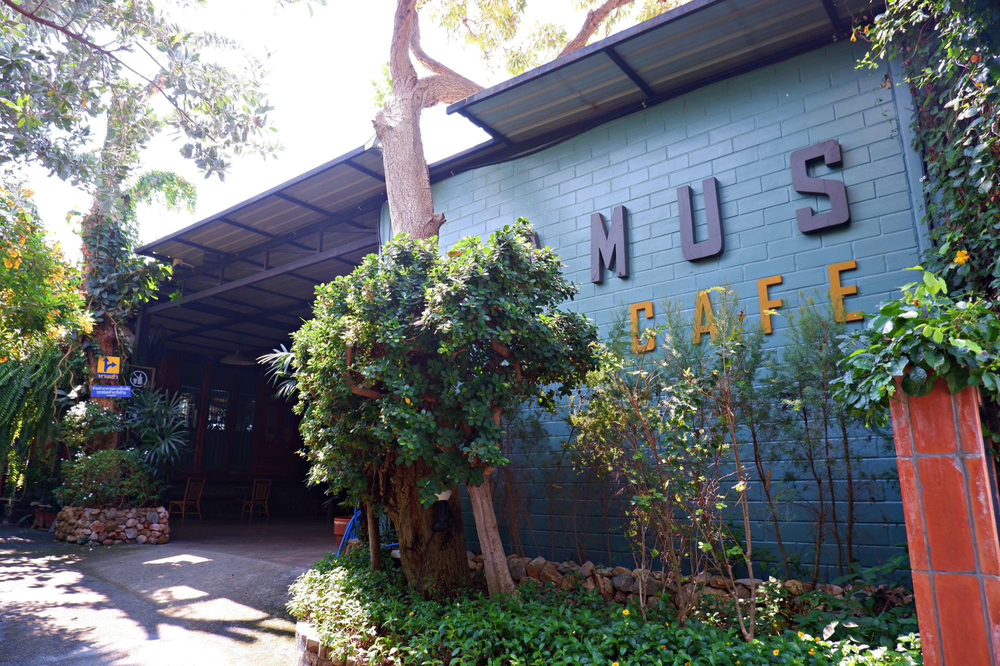 緑のレンガ壁が印象的なAdamus Cafeの外観