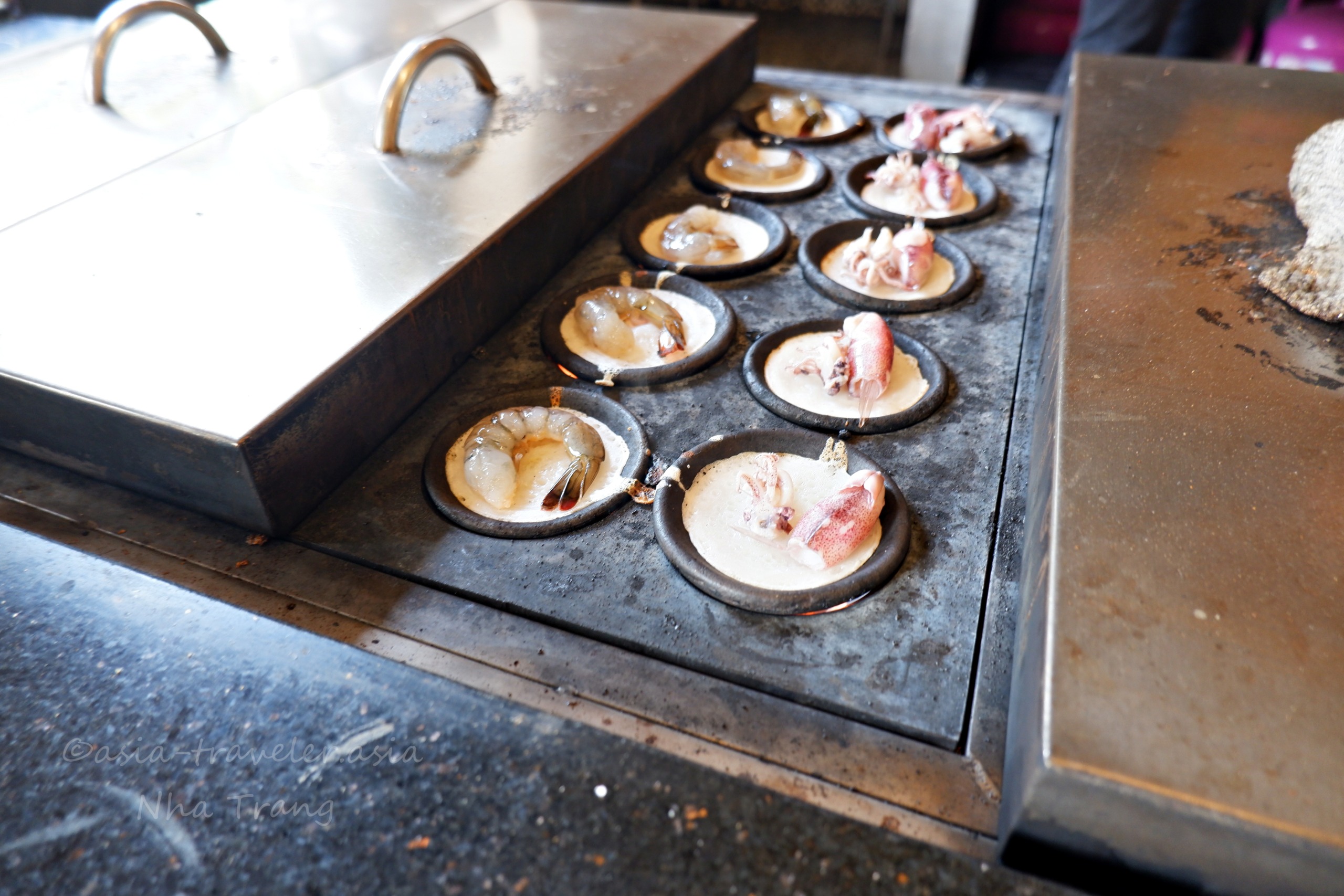 ニャチャンのバインカン専門店で海老とイカを鉄板焼きにする様子