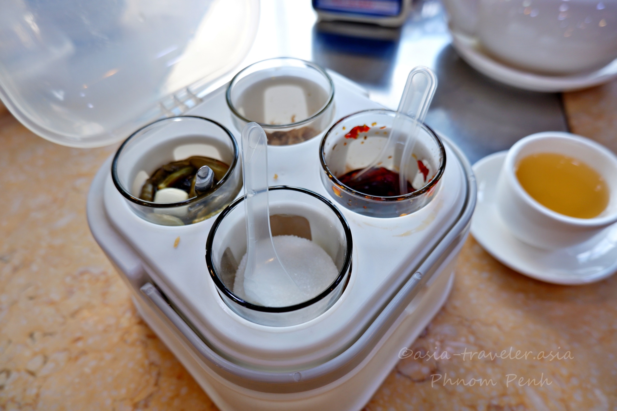 プノンペンの飲茶店に並ぶ黒酢・チリ・砂糖・生胡椒酢の卓上調味料セット