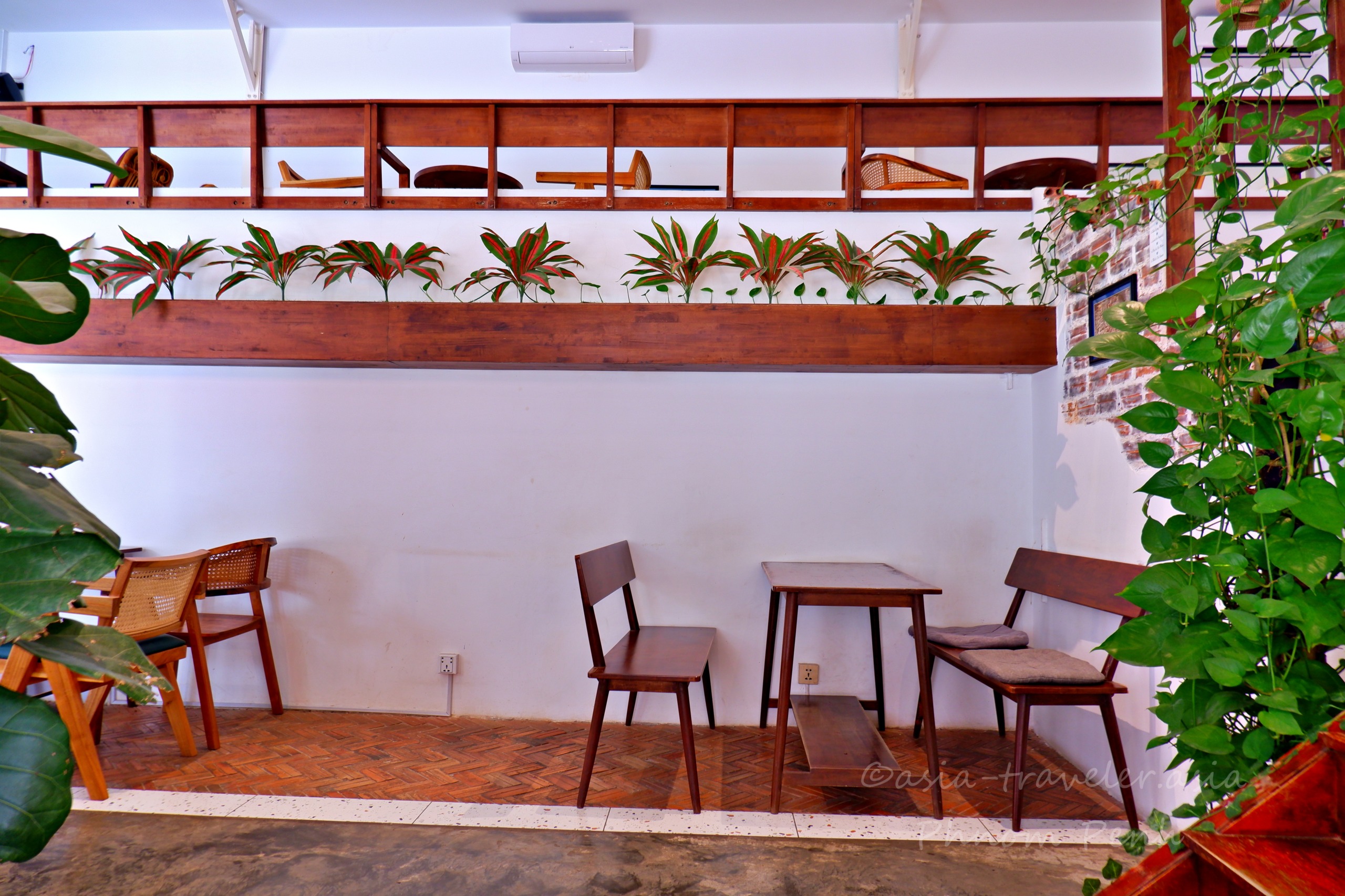 プノンペンの秋葉原カフェ店内の木製テーブルと観葉植物