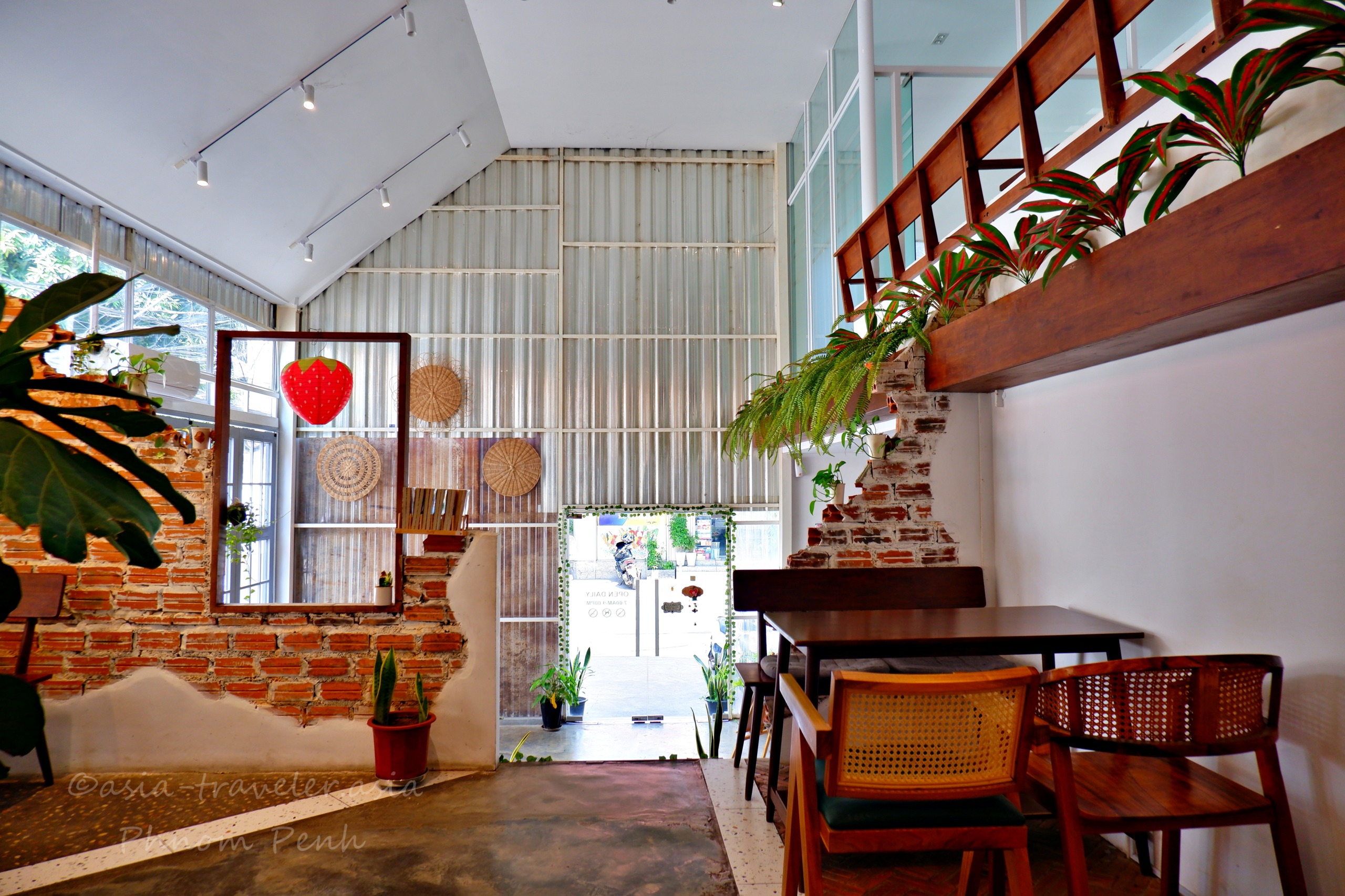 プノンペンの秋葉原カフェ、レンガ壁と木製階段のある店内