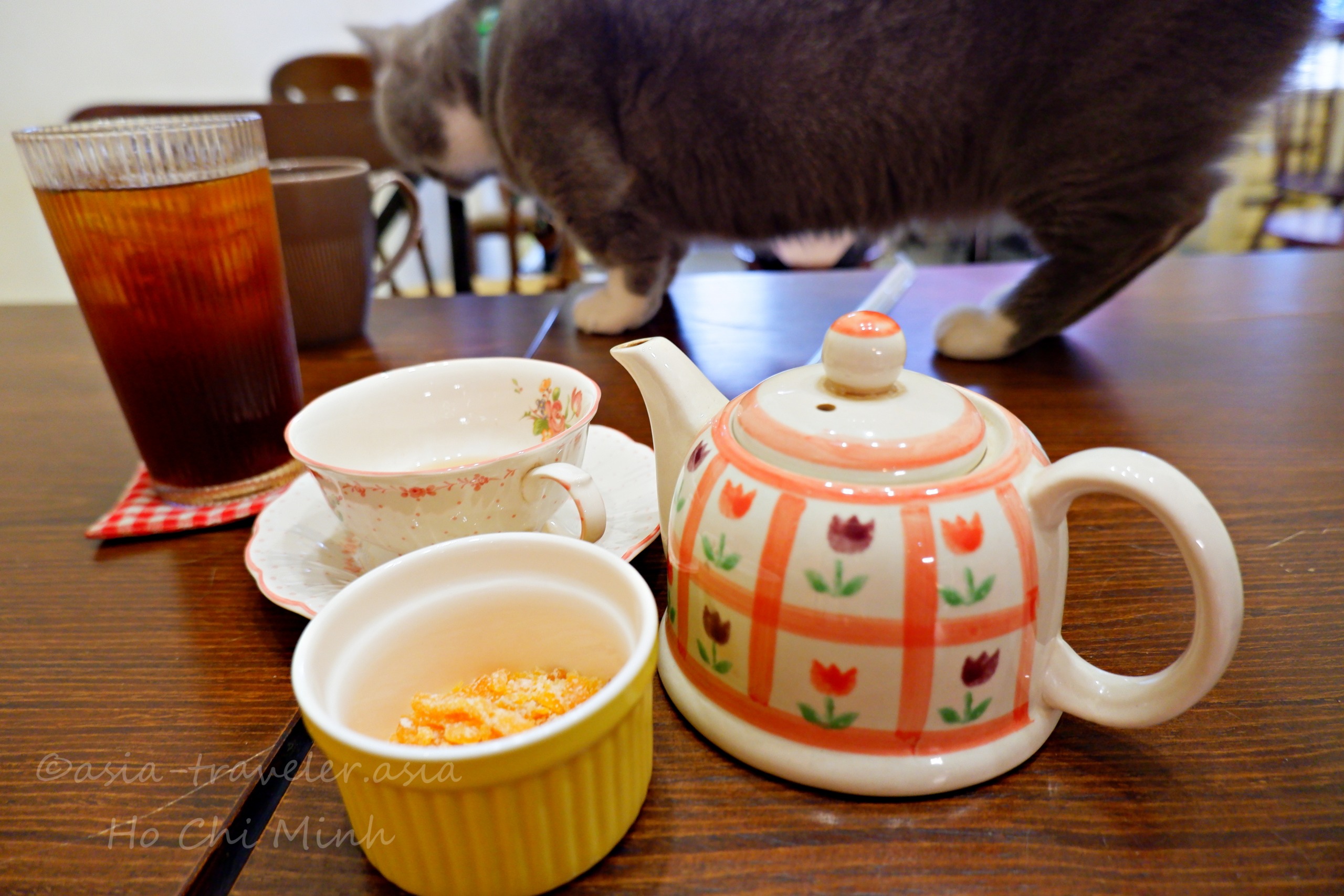Bittersweet Cafeの茶器とテーブルに近づく灰色猫クッキー