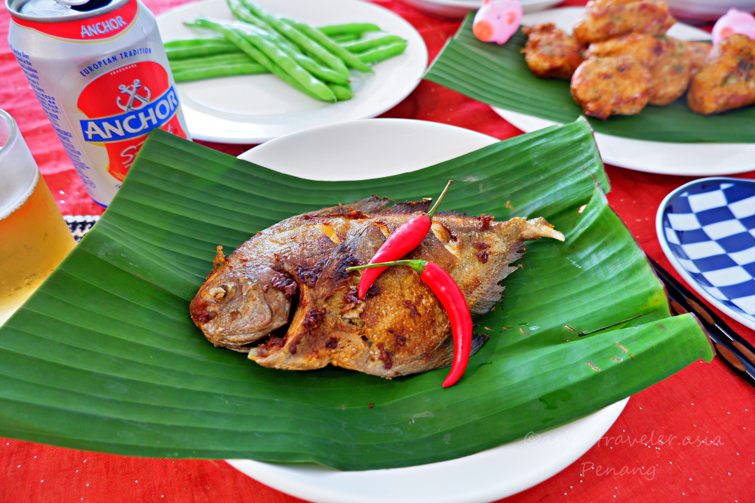 バナナの葉に盛られたクロアジモドキのスパイス揚げとアンカービール