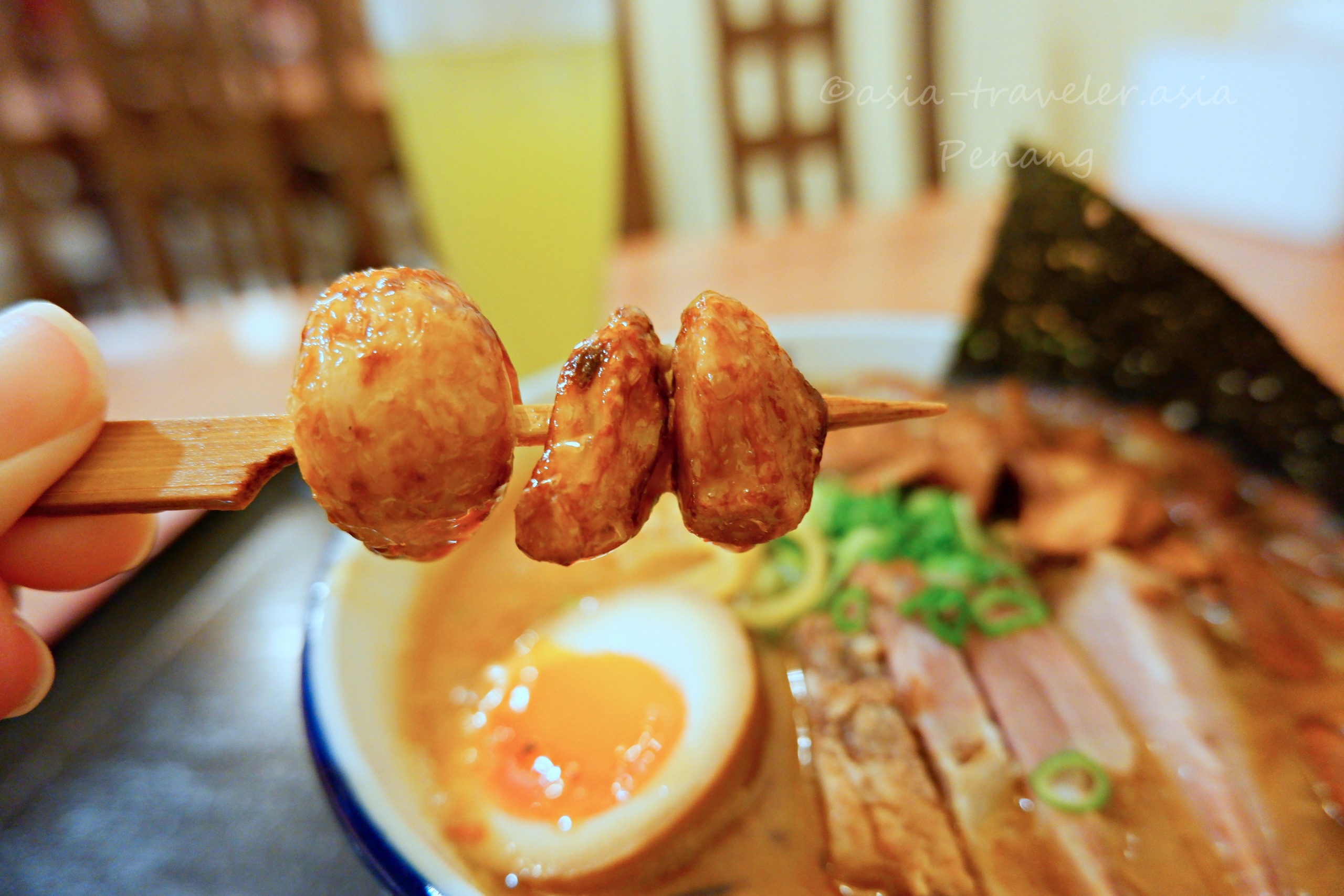 ペナン島・麺や雅の串焼きニンニクを箸でつまむアップ