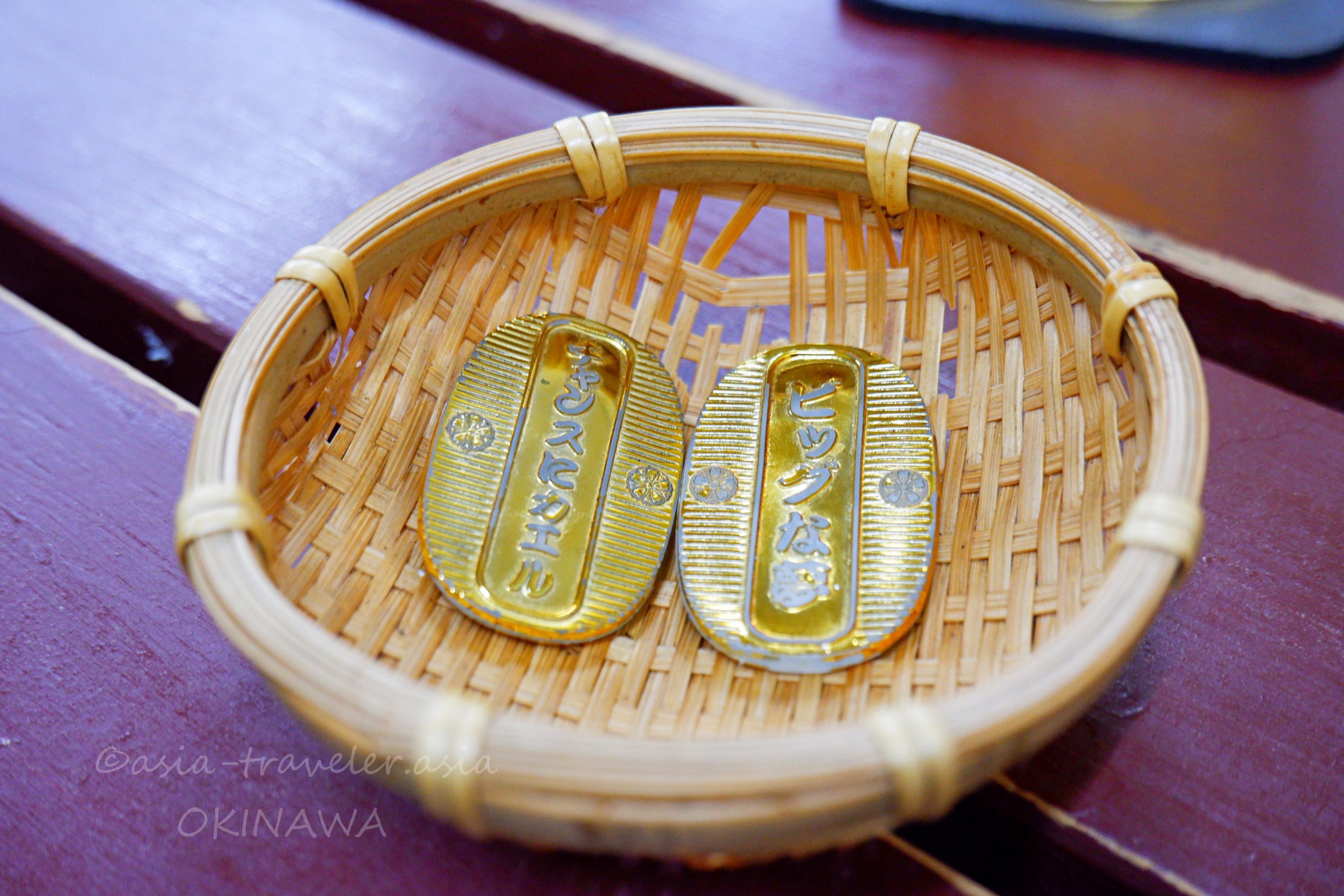 竹かごに入った仁ぐゎーせんべろドリンク引換用小判2枚