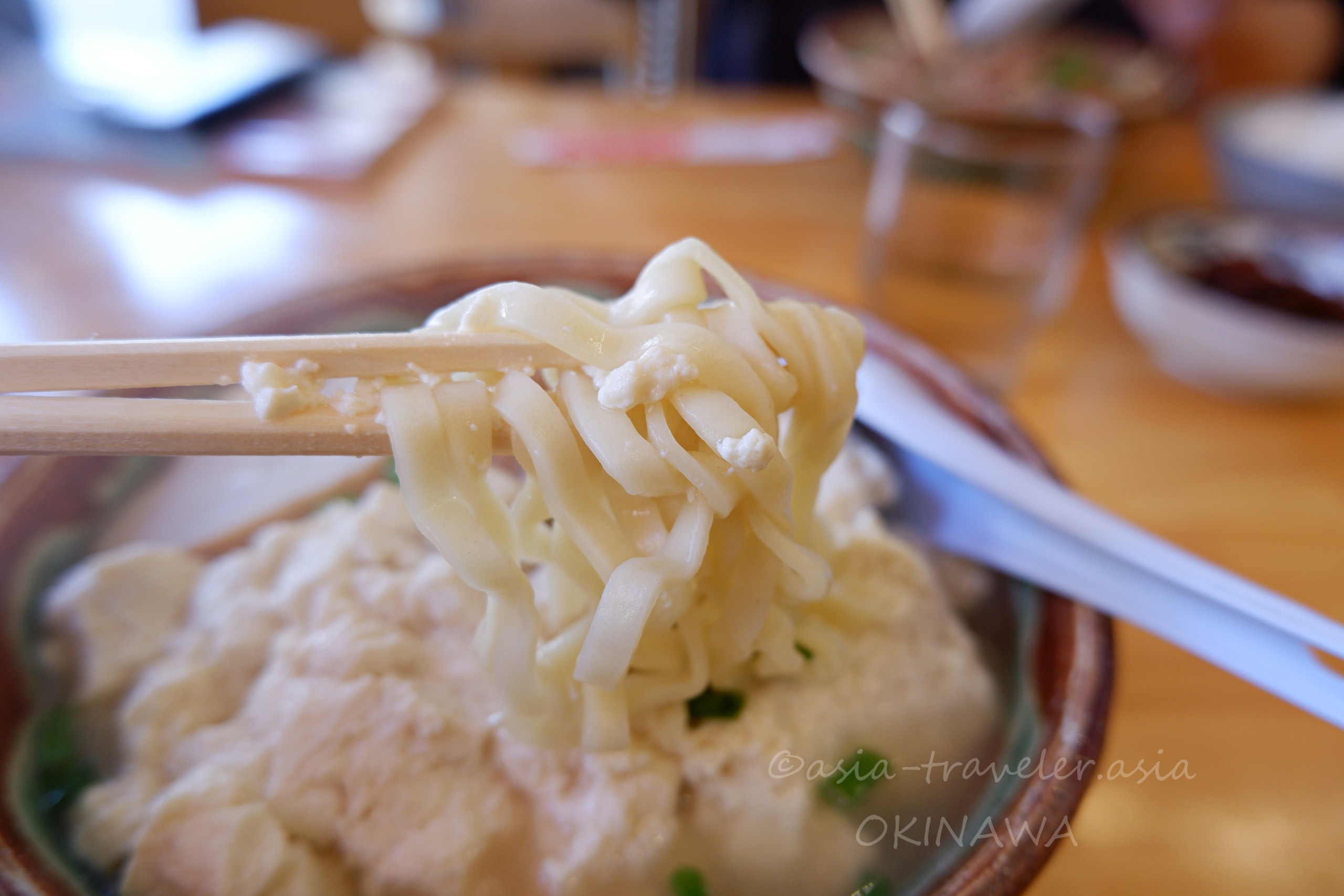 箸で持ち上げたゆし豆腐そばのちぢれ麺アップ