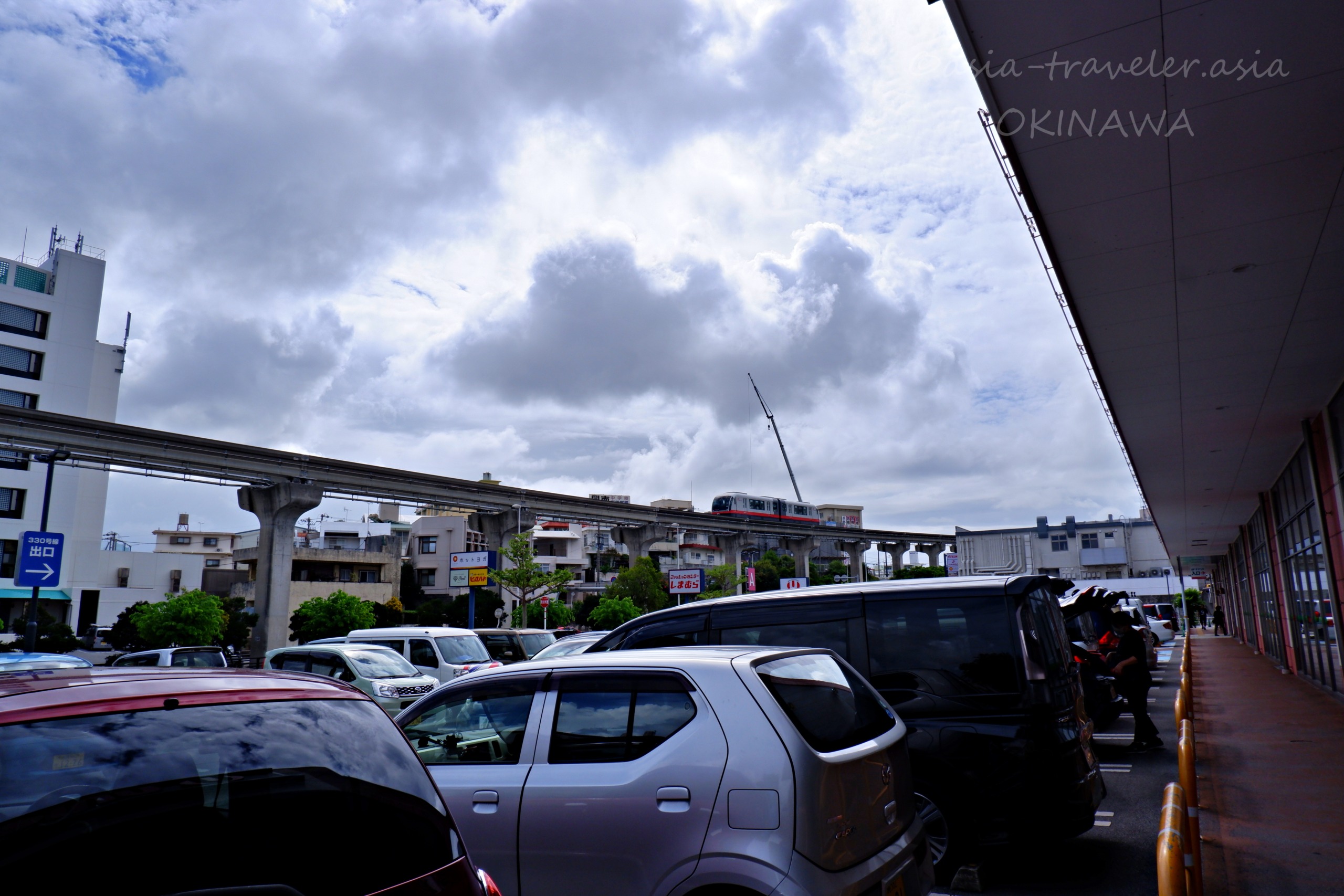 那覇・古島付近の駐車場とゆいレールが走る曇り空の風景