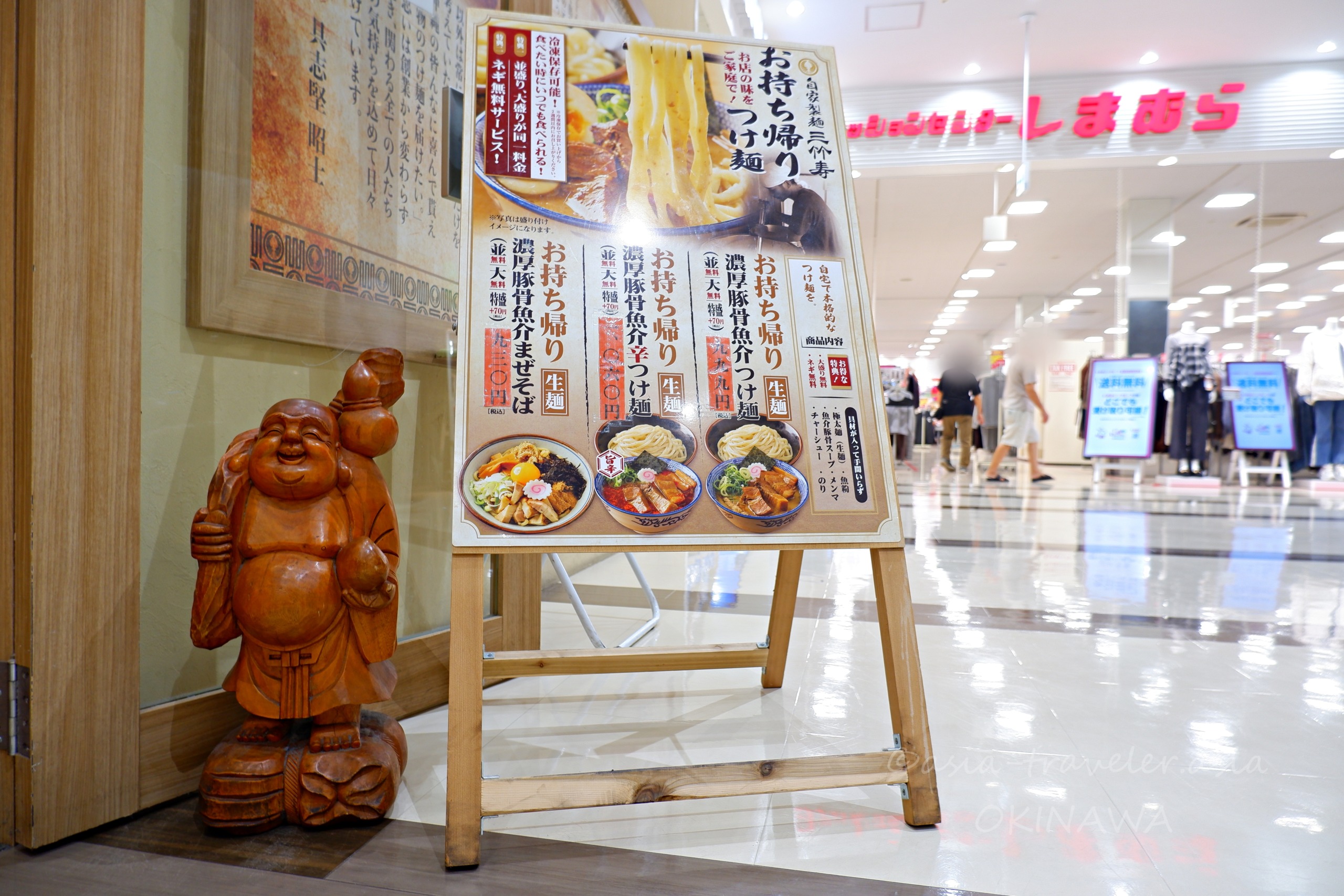 三竹寿店頭の木製布袋像とお持ち帰りつけ麺メニュー看板