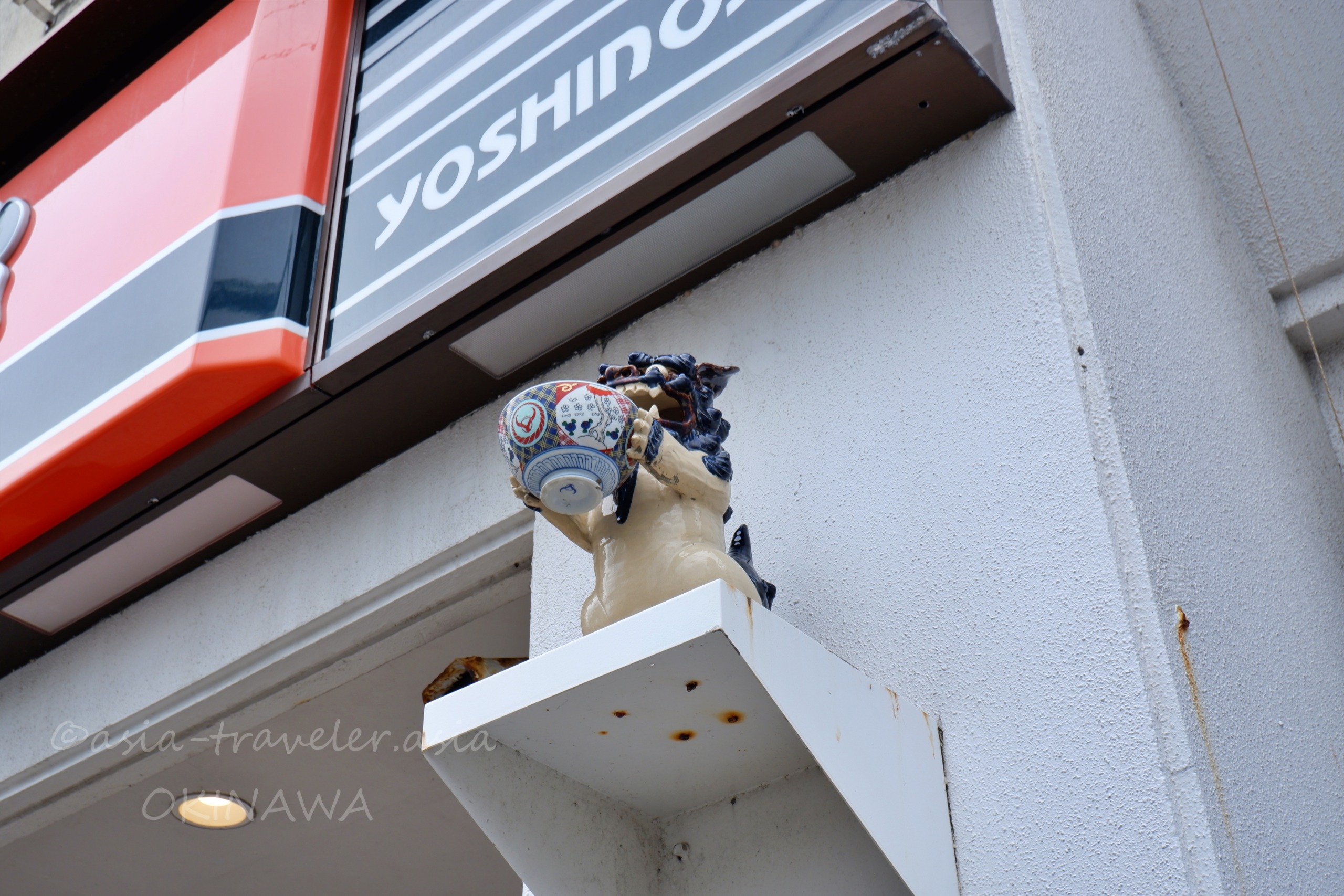 吉野家の丼を抱えたシーサーの置物と店舗外観