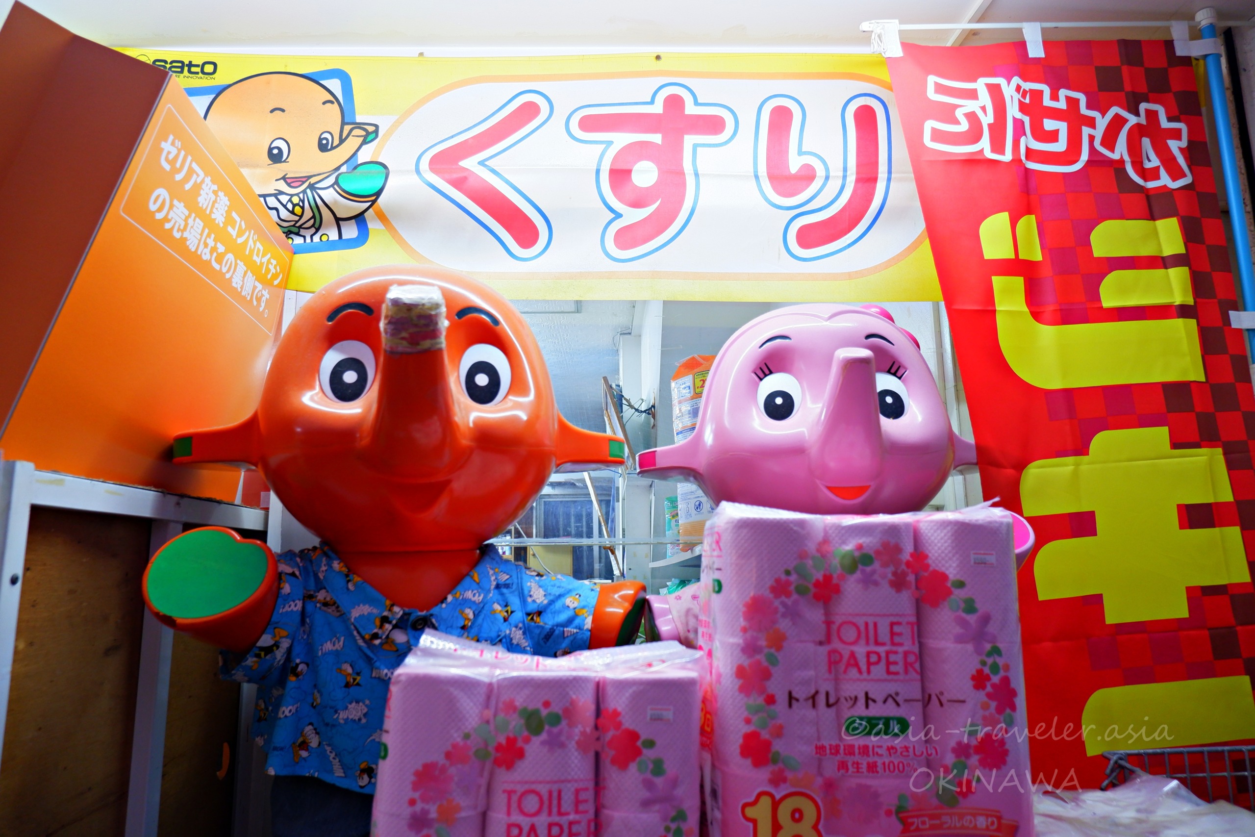 那覇・栄町のサトちゃんとサトコちゃんがかりゆし姿で薬局前に並ぶ