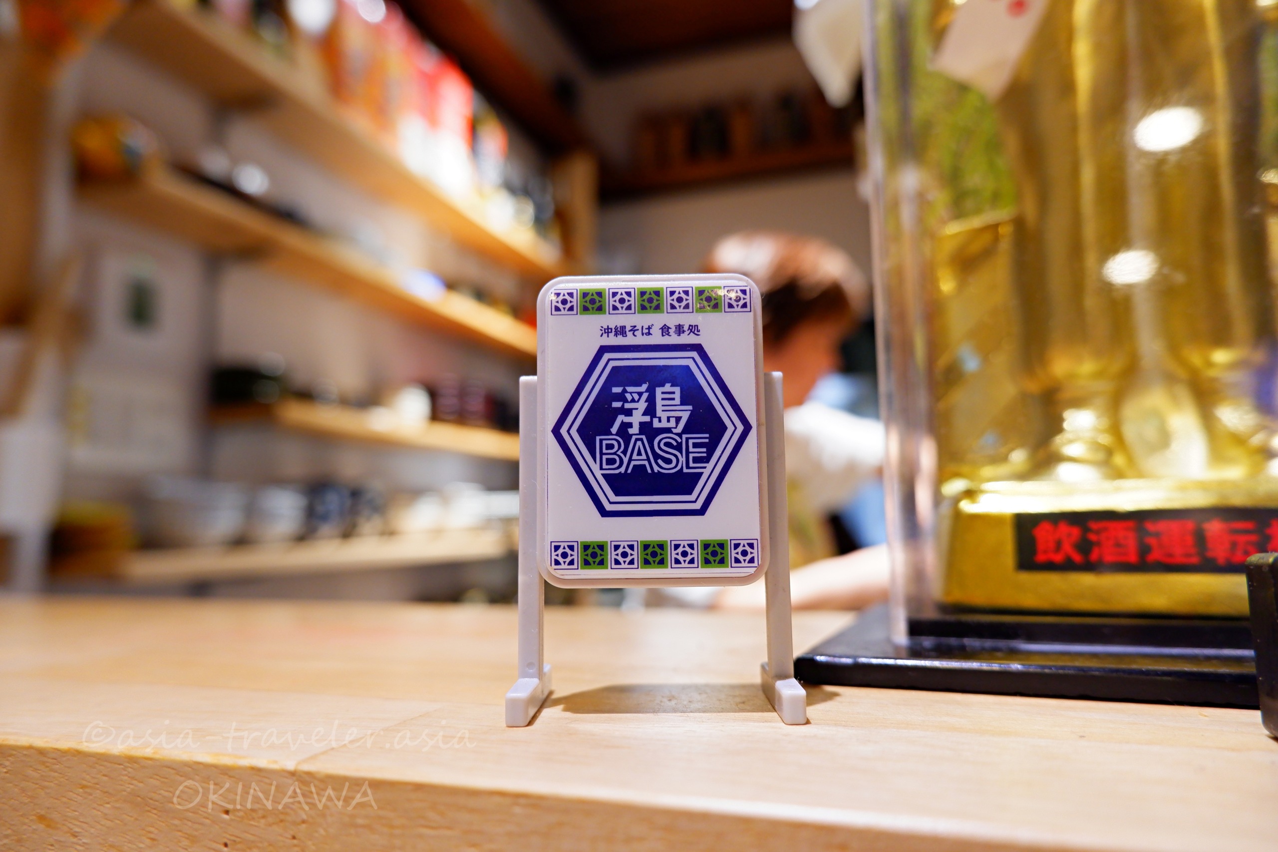 沖縄そば食事処・浮島BASEのカウンターに置かれた店名ロゴ看板