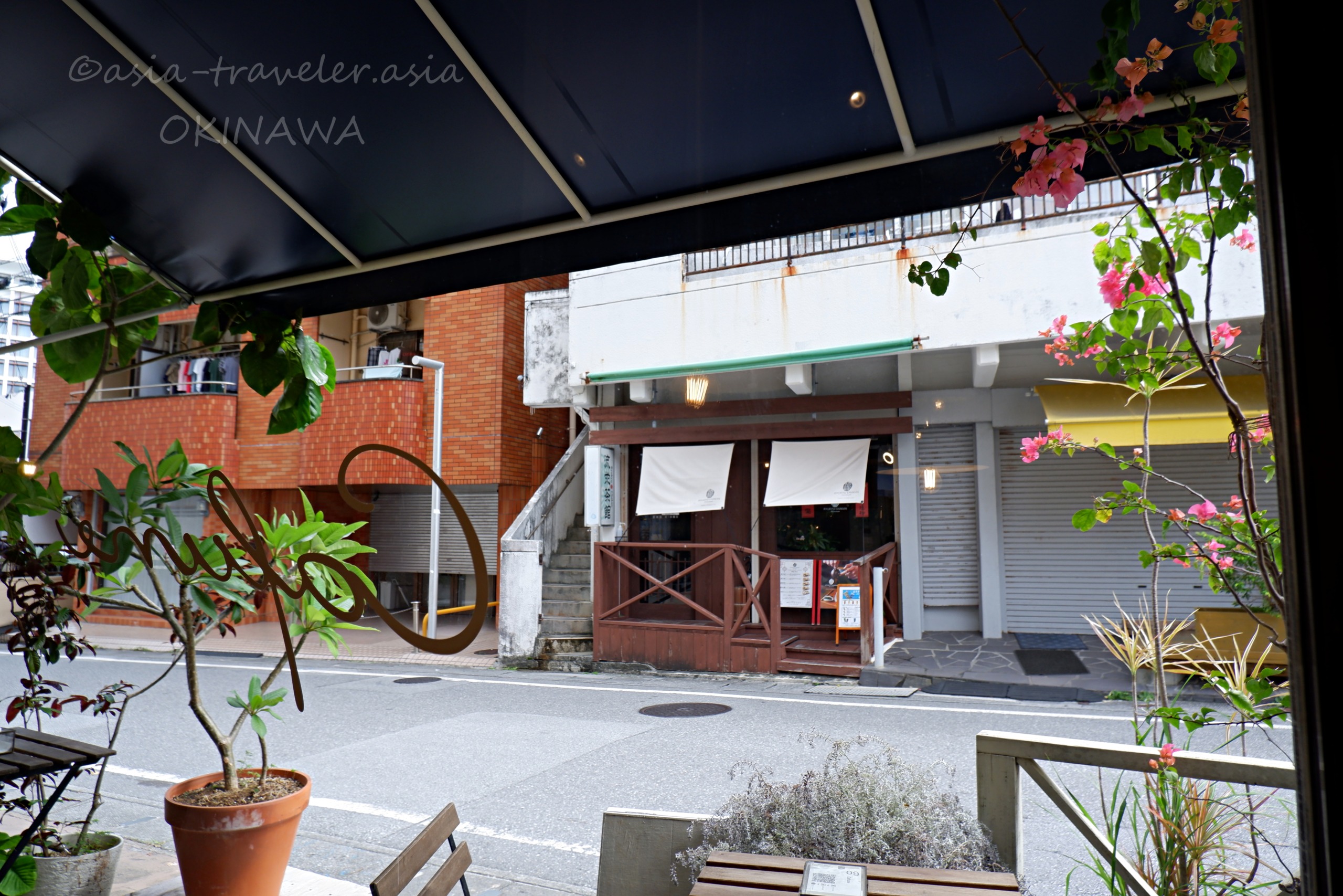 ニューパラダイス通りから見た対面の飲食店と緑のテラス席
