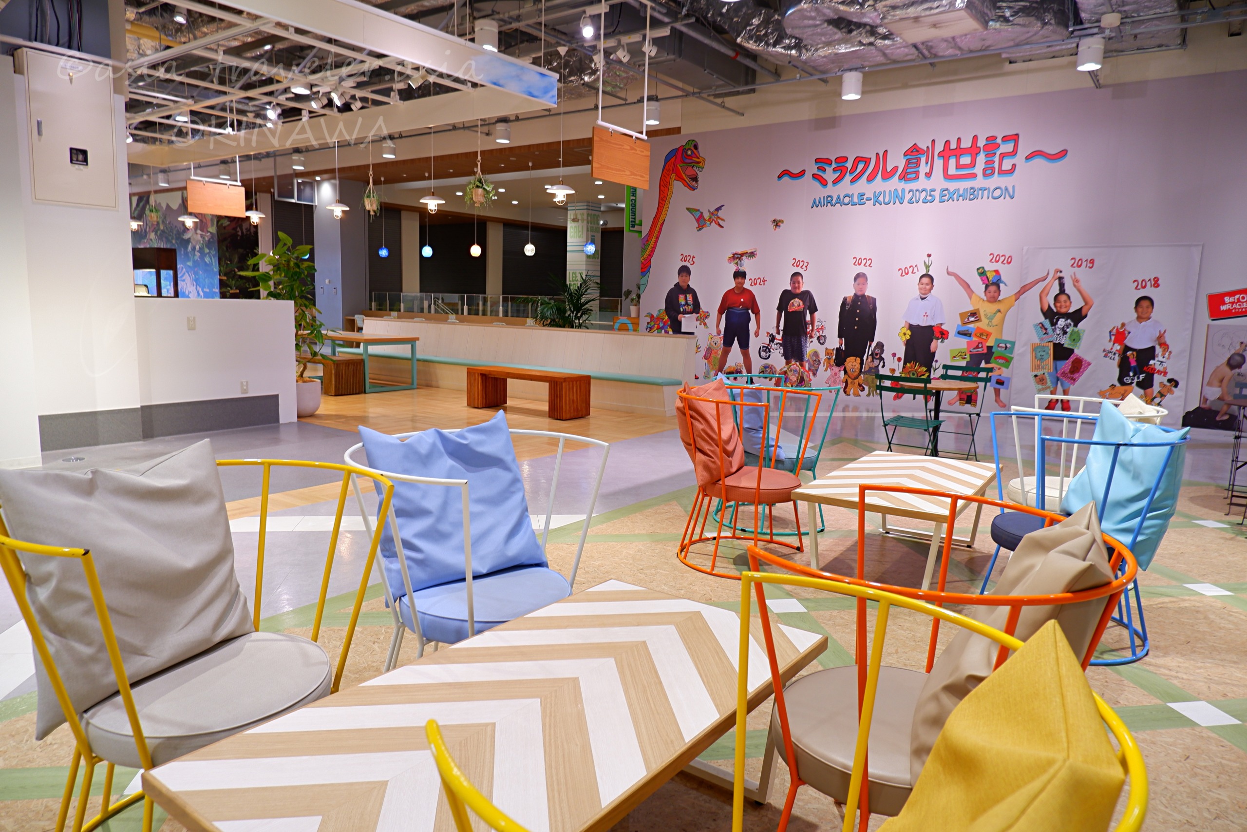 イーアス豊崎2階フリースペースのカラフルな椅子とミラクル創世記の壁画