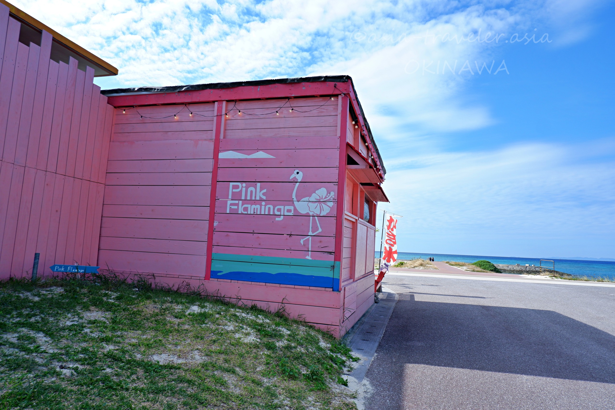 沖縄・豊崎海浜公園近くのPink Flamingo外観と青い海