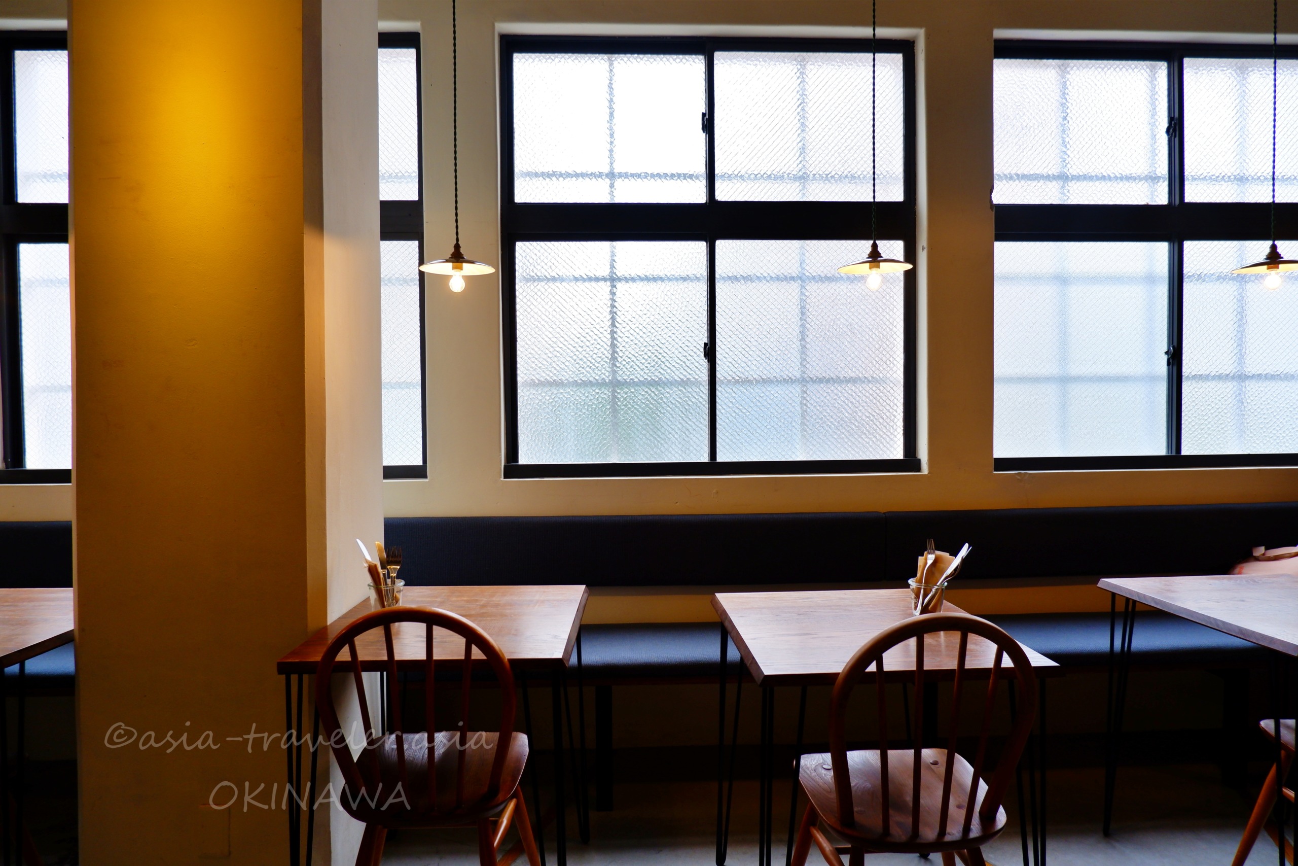 オハコルテベーカリー奥フロアの温かみある白熱灯と木製テーブル席