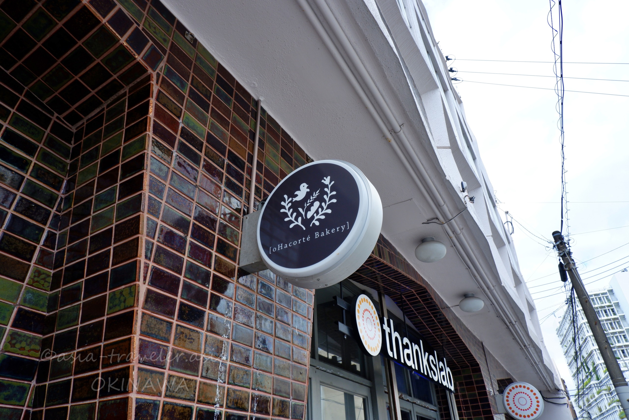 oHacorté Bakery泉崎店の煉瓦タイル外壁と丸い看板