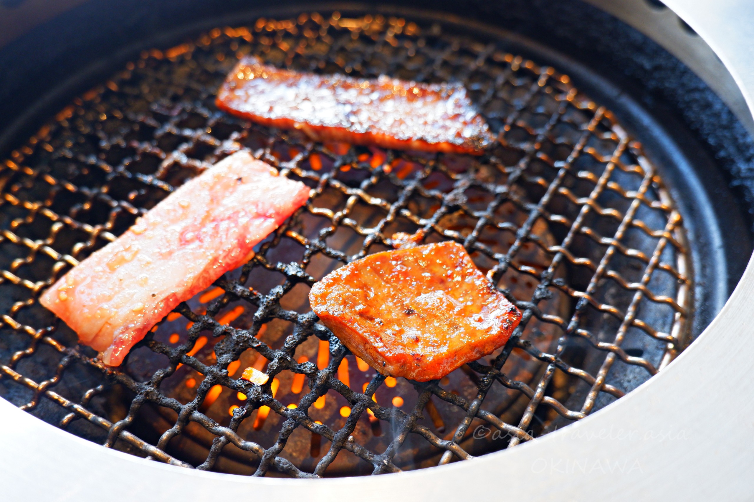 叙々苑のタレ漬けカルビと赤身肉を炭火で焼く様子