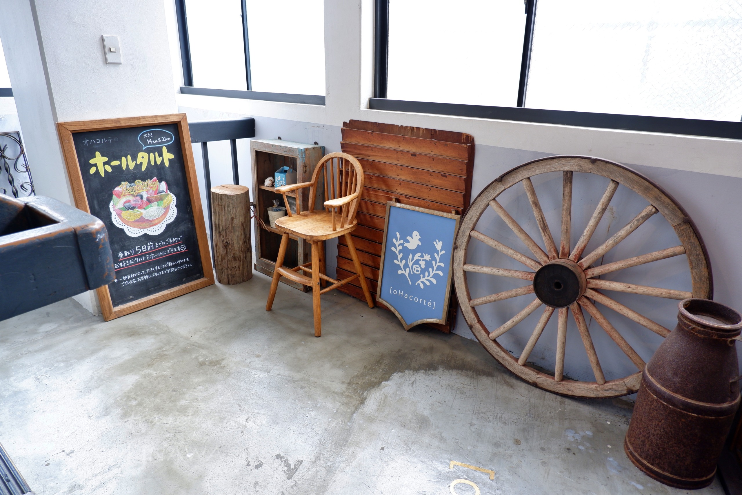 オハコルテベーカリーの木製車輪と黒板メニューが並ぶ店内ディスプレイ