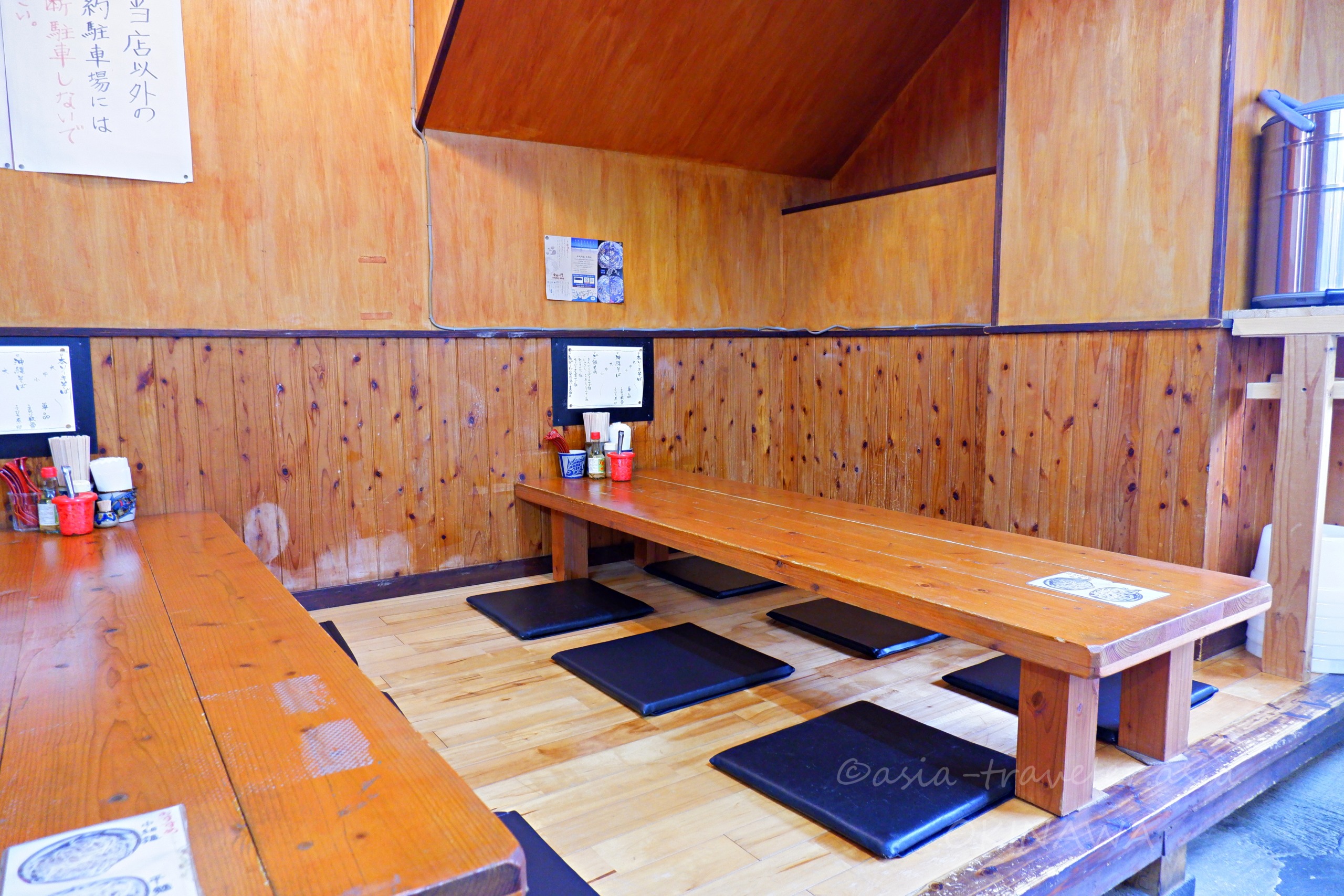 とらや店内の木製小上がり席と座布団が並ぶ落ち着いた空間