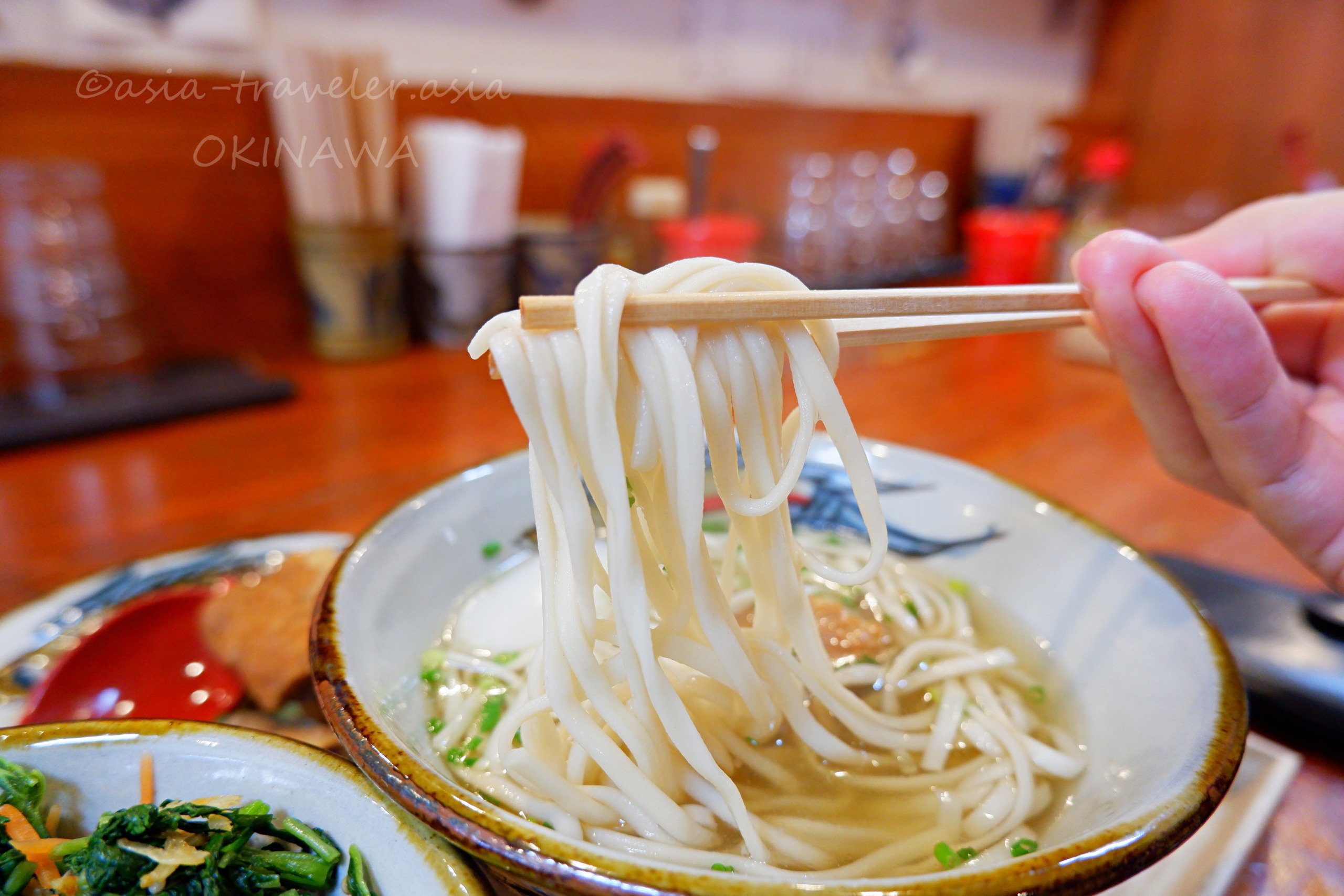 沖縄そばとらやの木灰細麺を箸で持ち上げる