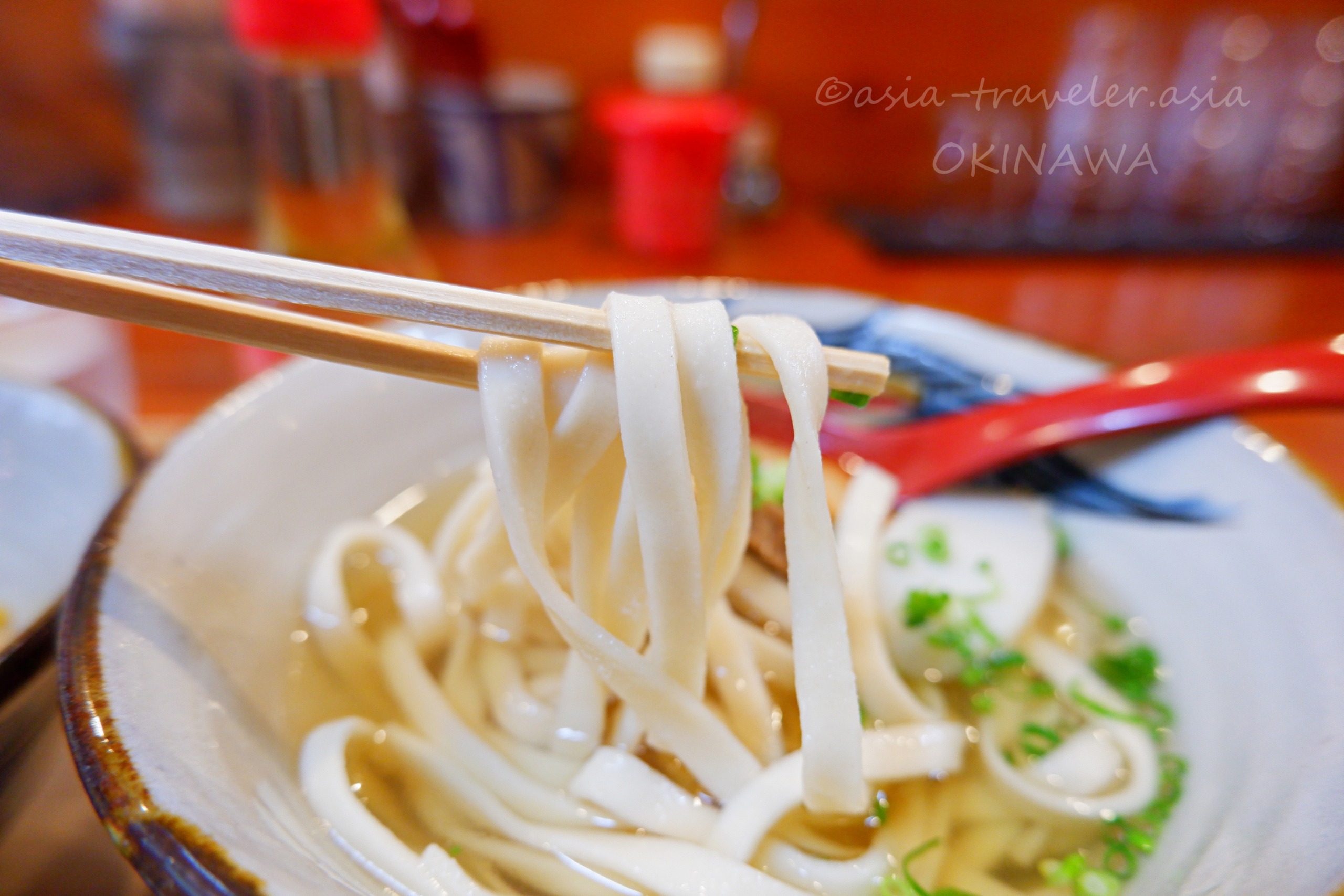 箸で持ち上げた木灰そばの平麺アップ