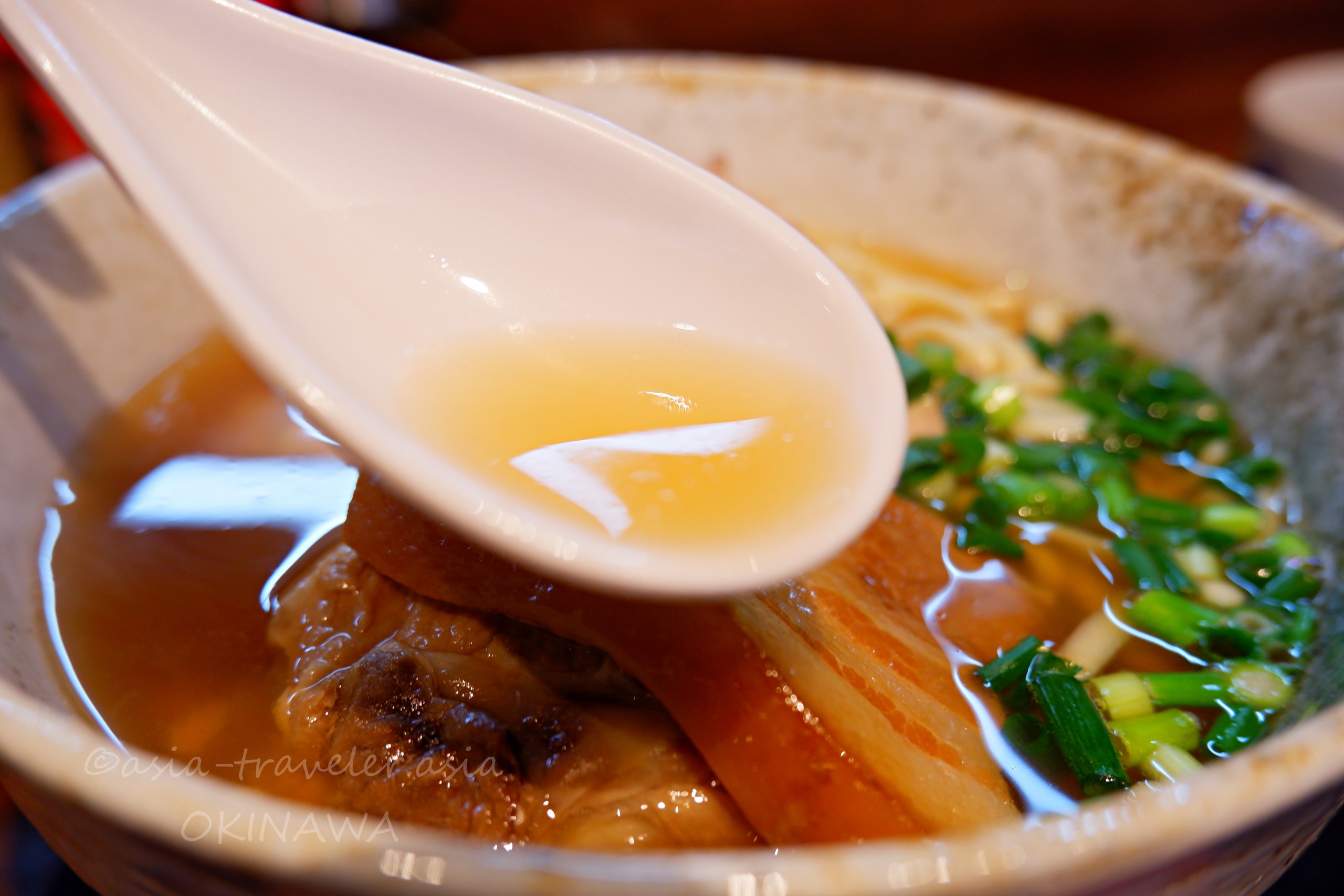 麺屋あんのありんくりんすばあっさりスープをレンゲで掬う