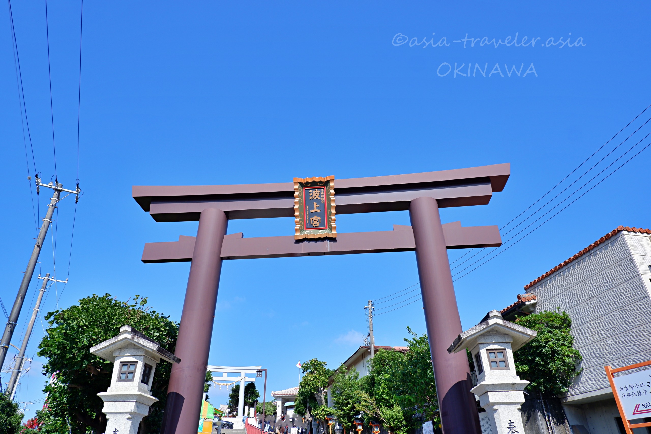青空にそびえる波上宮の大鳥居と石灯籠