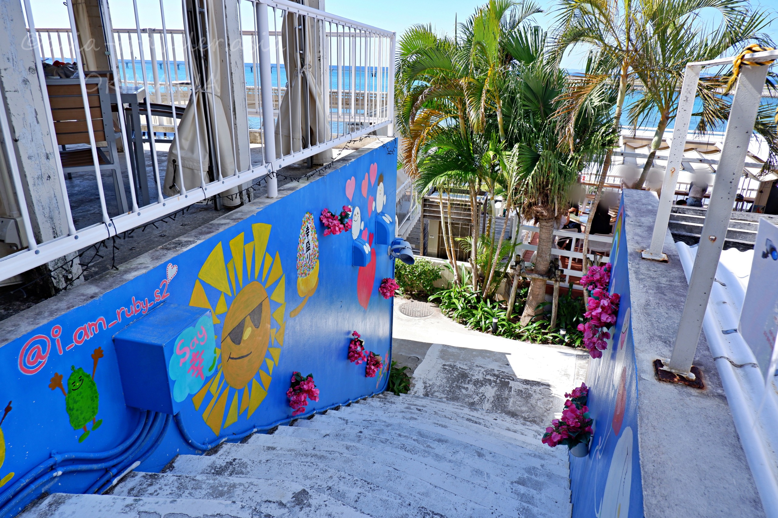 ウミカジテラスのカラフルな壁画と南国ヤシの階段