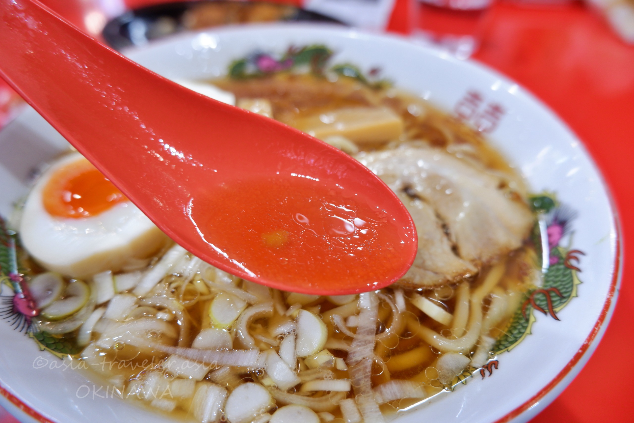 那覇・Agu豚の醤油ラーメンと赤いレンゲのアップ