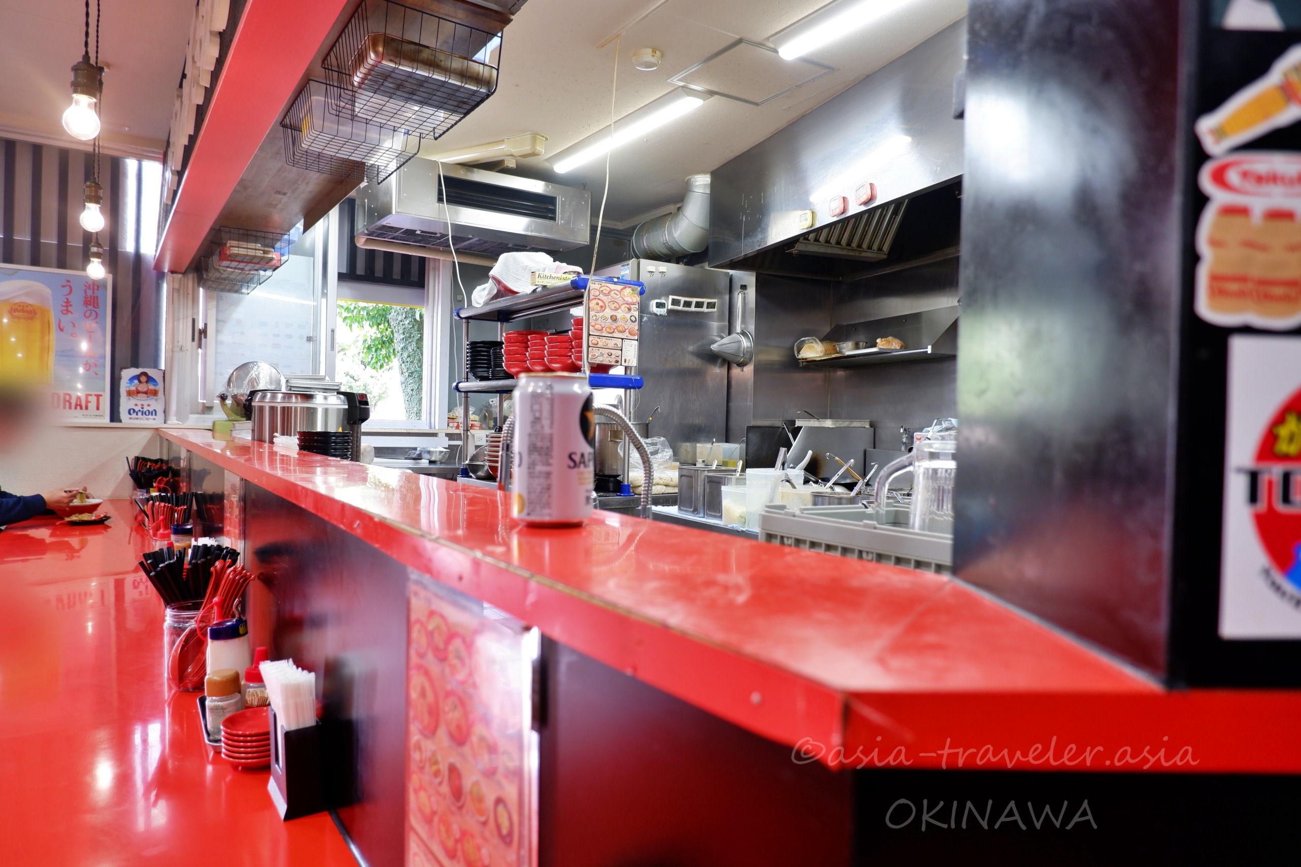 那覇・Agu豚久茂地店の赤いカウンターと厨房